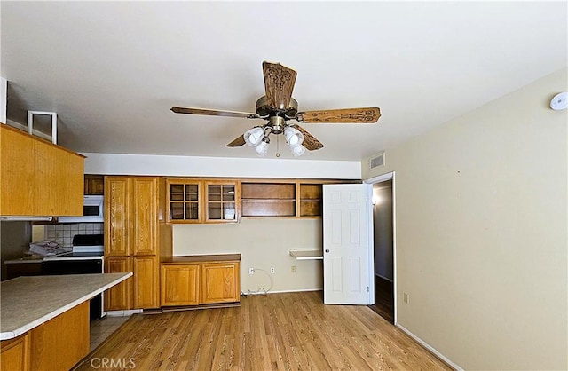 kitchen featuring decorative backsplash, light hardwood / wood-style floors, range with electric stovetop, and ceiling fan