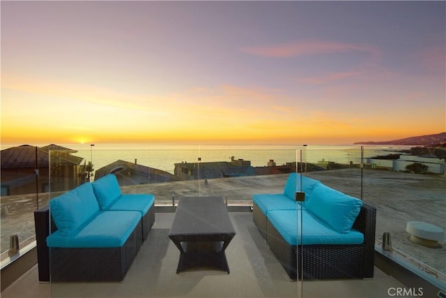 patio terrace at dusk with a water view and an outdoor hangout area