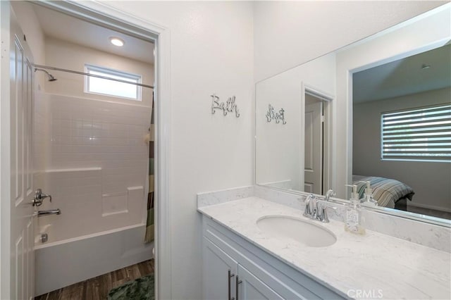 bathroom featuring hardwood / wood-style floors, vanity, and shower / washtub combination