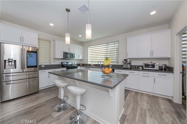 kitchen featuring white cabinets, appliances with stainless steel finishes, and a center island