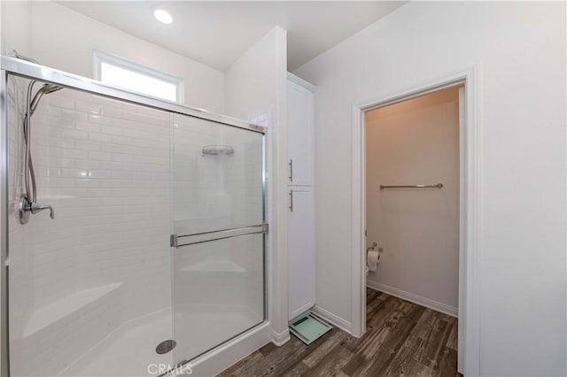 bathroom with wood-type flooring and a shower with door