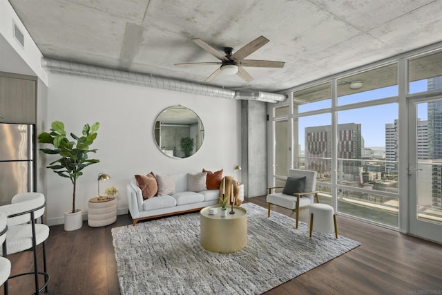 living room featuring dark wood-type flooring, ceiling fan, and expansive windows