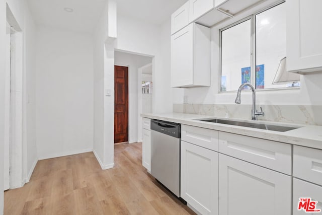 kitchen featuring light stone countertops, sink, white cabinetry, and stainless steel dishwasher