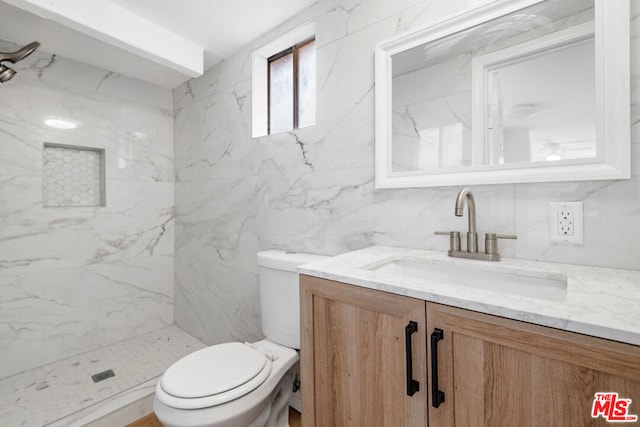 bathroom featuring tile walls, toilet, vanity, and tiled shower