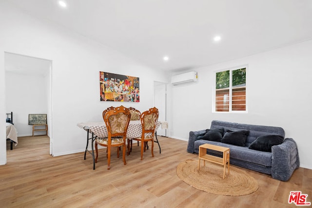 living room featuring a wall unit AC and light hardwood / wood-style floors