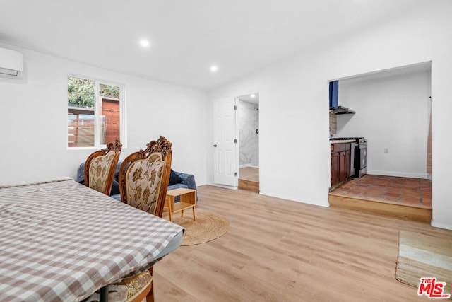 bedroom featuring light hardwood / wood-style flooring and a wall mounted air conditioner