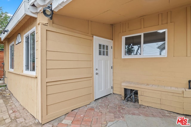 view of exterior entry with a patio area