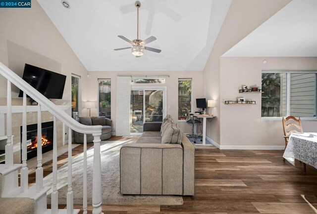 living room with ceiling fan, dark hardwood / wood-style floors, and vaulted ceiling