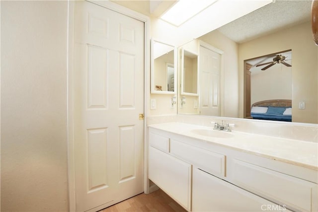 bathroom with ceiling fan, hardwood / wood-style floors, and vanity