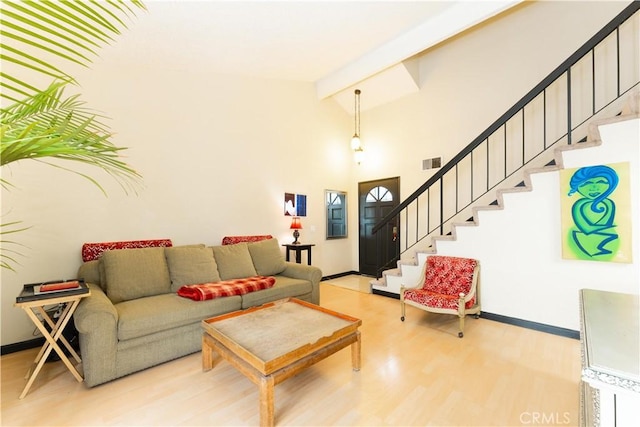 living room featuring lofted ceiling with beams and light wood-type flooring