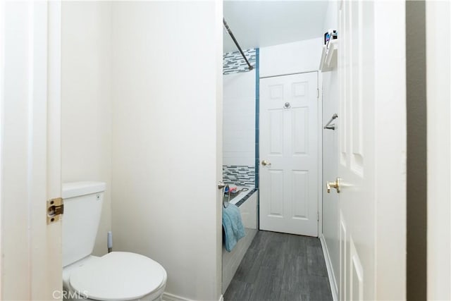 bathroom featuring hardwood / wood-style flooring, backsplash, and toilet