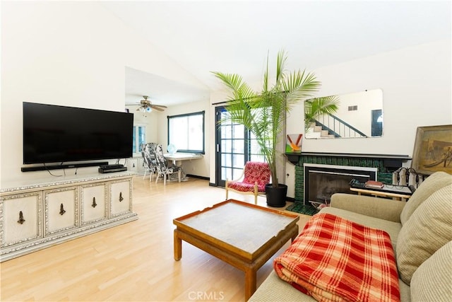 living room featuring lofted ceiling, ceiling fan, and light hardwood / wood-style floors