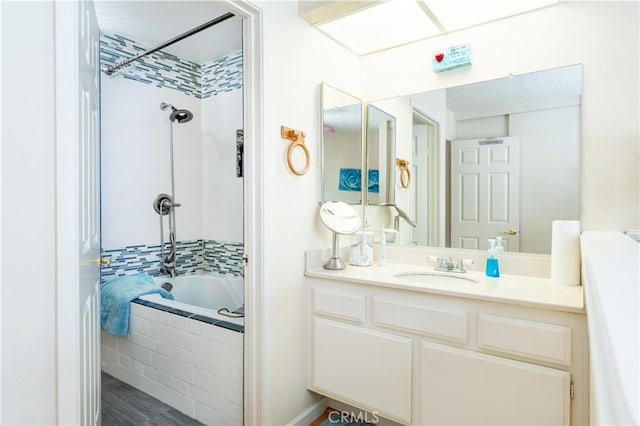 bathroom featuring tiled shower / bath and vanity