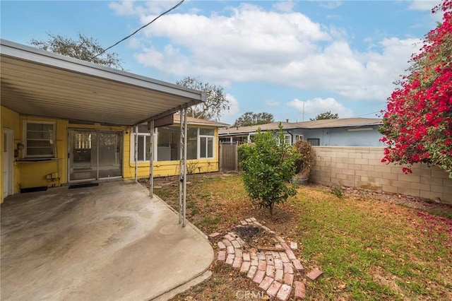 view of yard with a carport and a sunroom