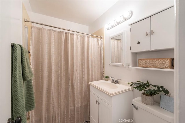 bathroom featuring toilet, vanity, and a shower with shower curtain