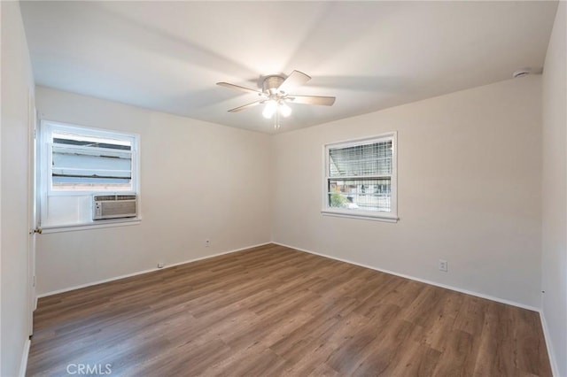 spare room featuring ceiling fan, cooling unit, and dark hardwood / wood-style floors