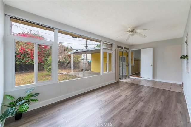 unfurnished sunroom with ceiling fan