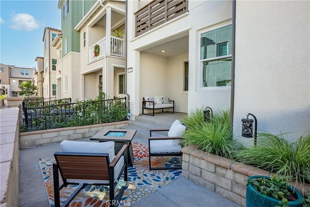 view of patio / terrace with a balcony and a fire pit