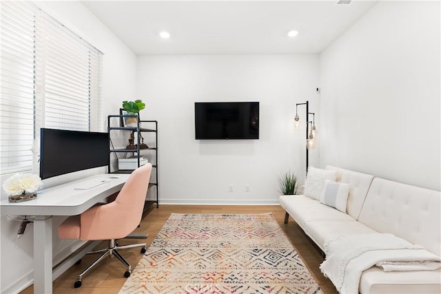 office space with plenty of natural light and hardwood / wood-style floors