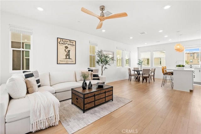 living room featuring light wood-type flooring and ceiling fan