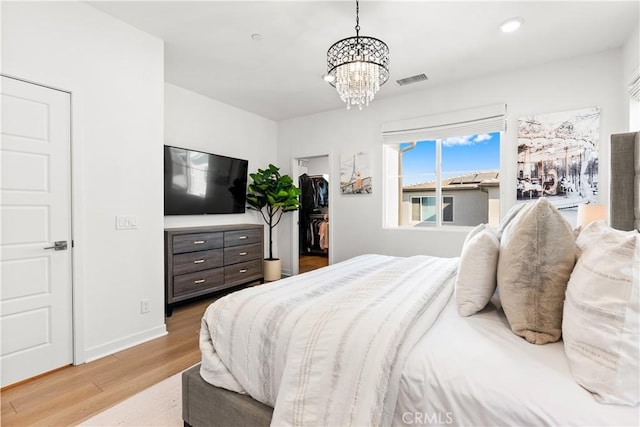 bedroom featuring a notable chandelier and light hardwood / wood-style floors