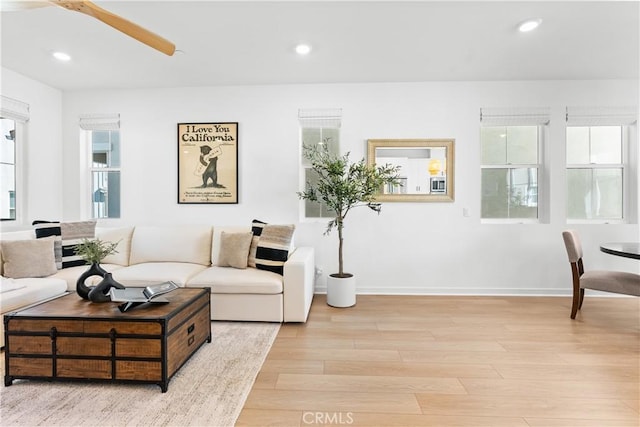 living room featuring light wood-type flooring and ceiling fan