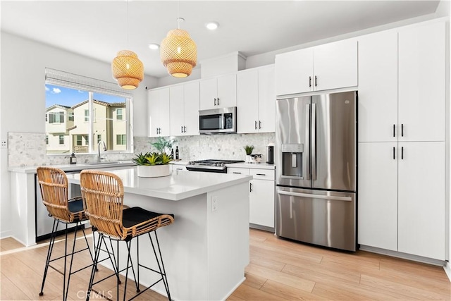 kitchen featuring pendant lighting, white cabinets, and stainless steel appliances