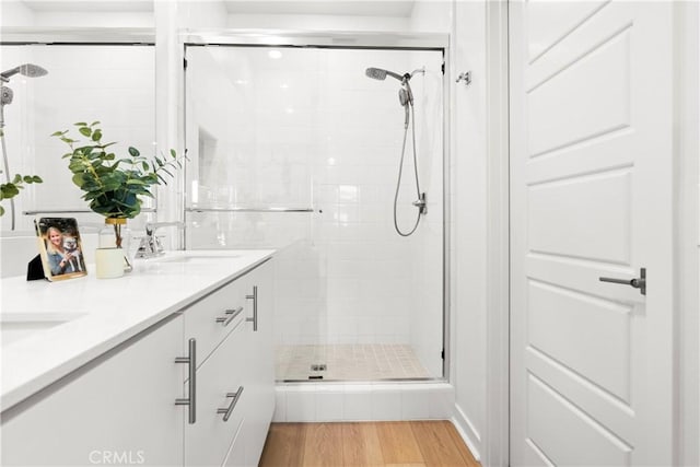 bathroom featuring a shower with shower door, wood-type flooring, and vanity