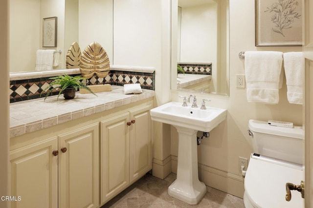 bathroom with toilet, tile patterned flooring, and decorative backsplash