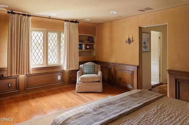 sitting room with wood-type flooring and built in features