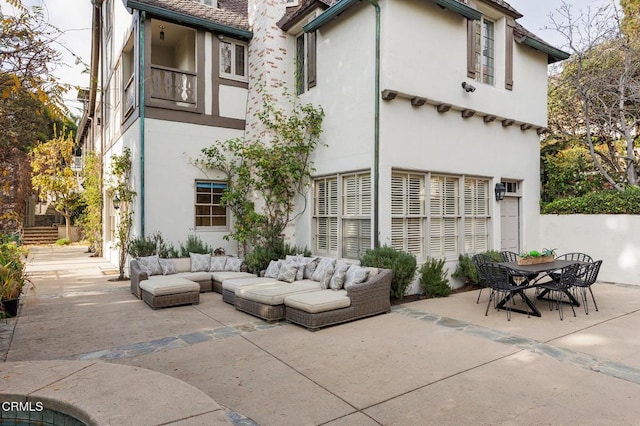 rear view of house with an outdoor living space and a patio