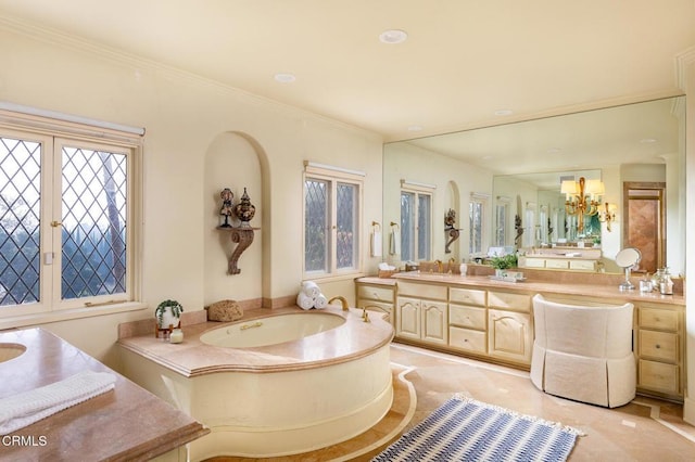 bathroom with ornamental molding, a tub to relax in, vanity, and a notable chandelier