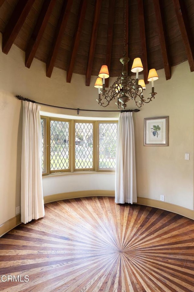 spare room with vaulted ceiling with beams, wood ceiling, and a chandelier