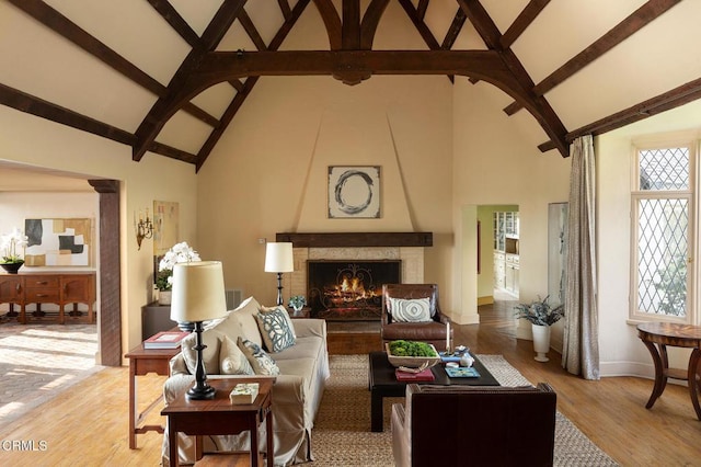 living room with a fireplace, light hardwood / wood-style flooring, and high vaulted ceiling