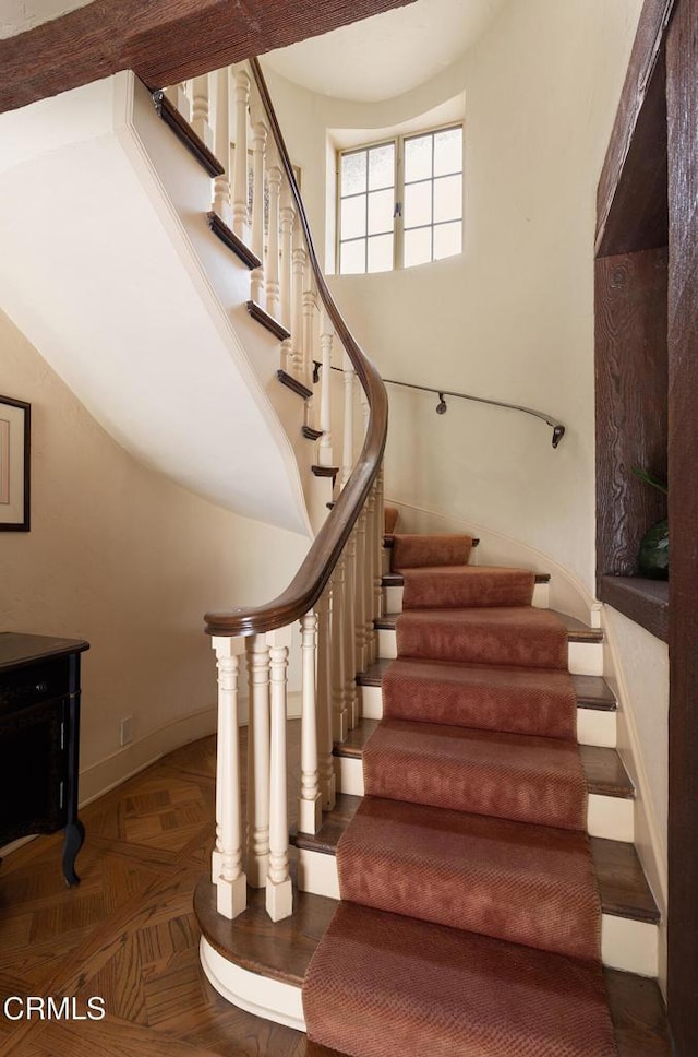 stairway featuring parquet floors