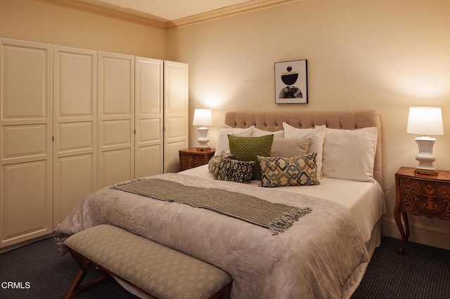 bedroom with a closet, crown molding, and dark colored carpet