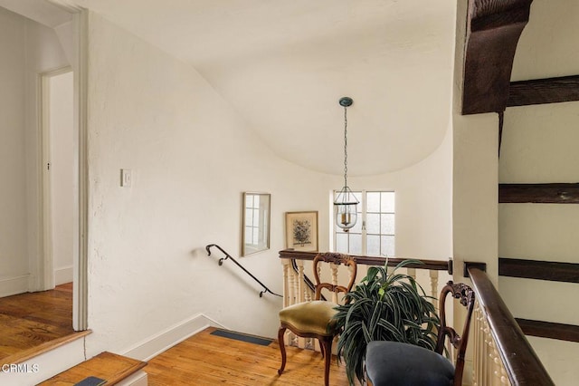 stairs with vaulted ceiling and hardwood / wood-style floors