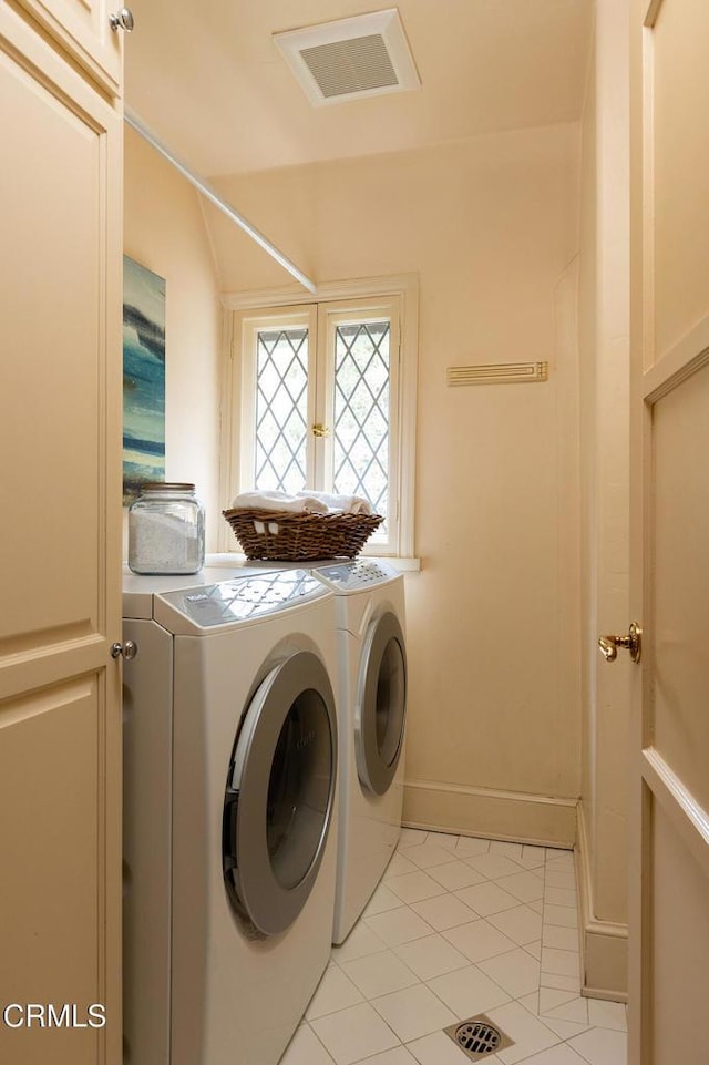 clothes washing area featuring washing machine and dryer and light tile patterned flooring