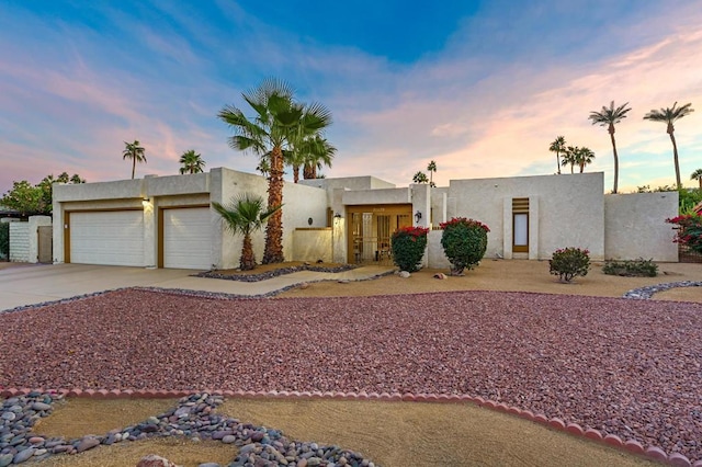 pueblo-style house featuring a garage