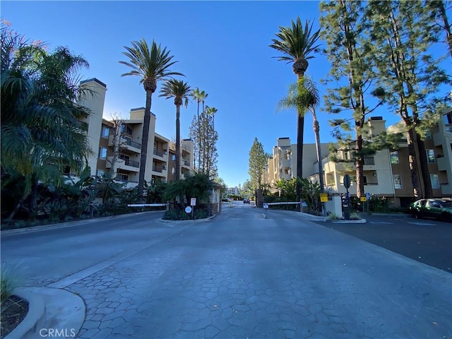 view of street featuring a gated entry and curbs