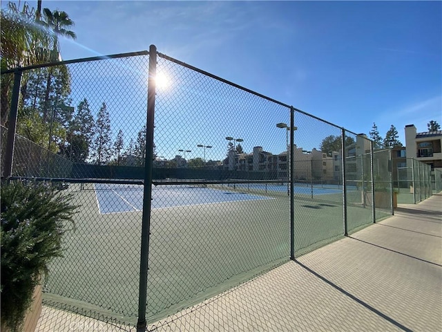 view of tennis court featuring fence