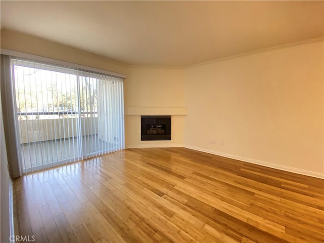 unfurnished living room with crown molding and hardwood / wood-style floors