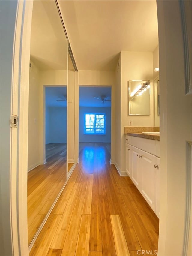 corridor featuring sink and light hardwood / wood-style flooring