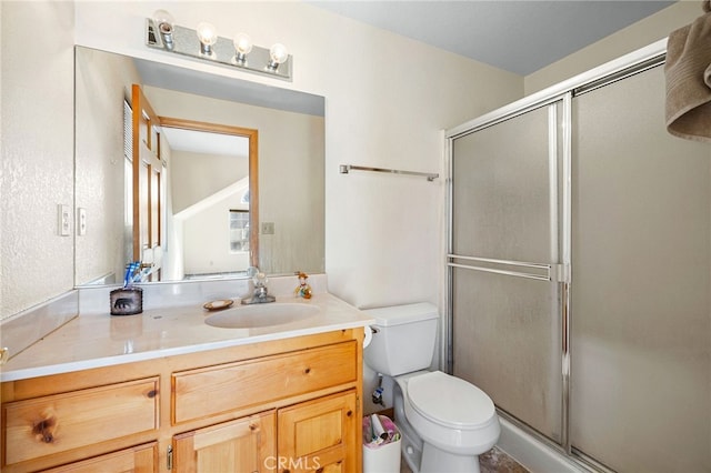 bathroom with toilet, an enclosed shower, and vanity