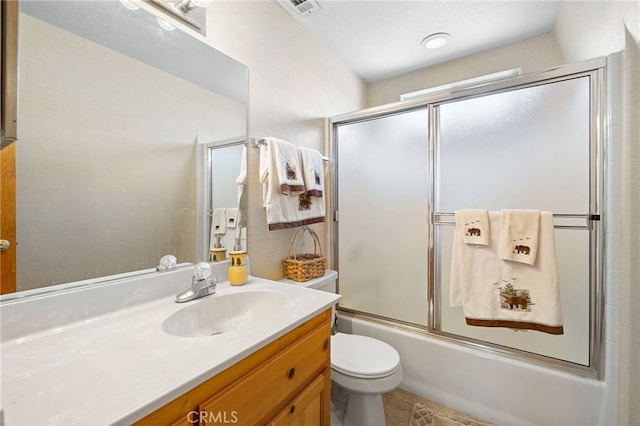 full bathroom featuring combined bath / shower with glass door, vanity, and toilet