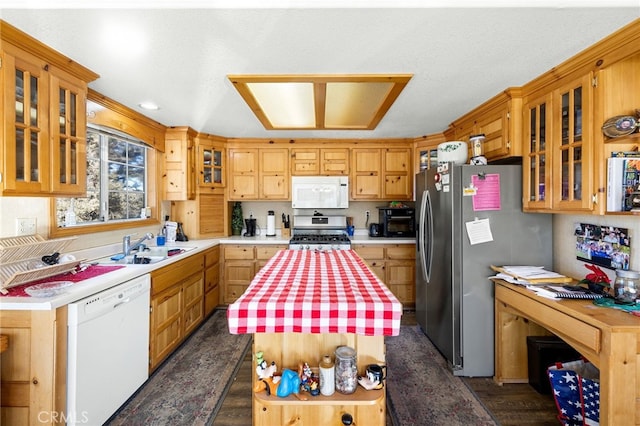 kitchen with a center island, sink, appliances with stainless steel finishes, a textured ceiling, and dark hardwood / wood-style flooring