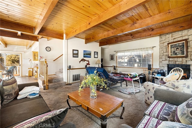 living room featuring beam ceiling, carpet floors, a stone fireplace, and wooden ceiling