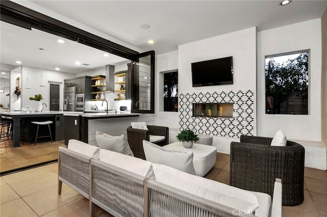 living room featuring a tiled fireplace and light tile patterned floors