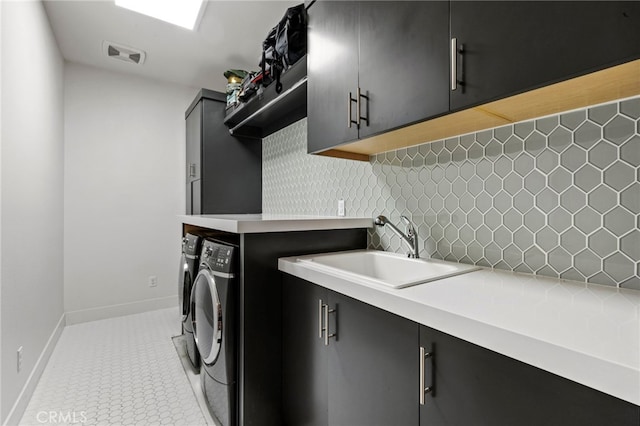 washroom with cabinets, sink, tile patterned flooring, and washing machine and clothes dryer