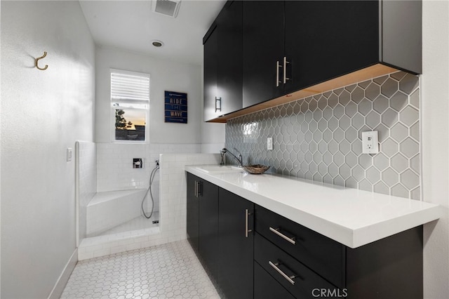 clothes washing area featuring sink and light tile patterned floors